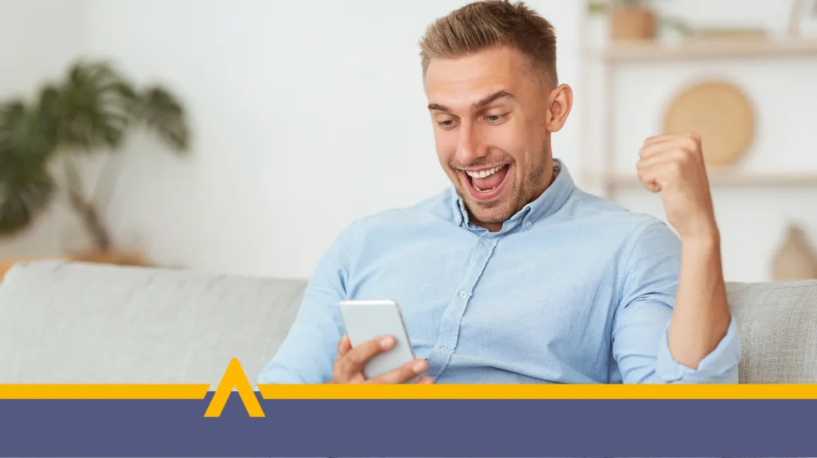 Zadowolony mężczyzna na kanapie z telefonem w ręce